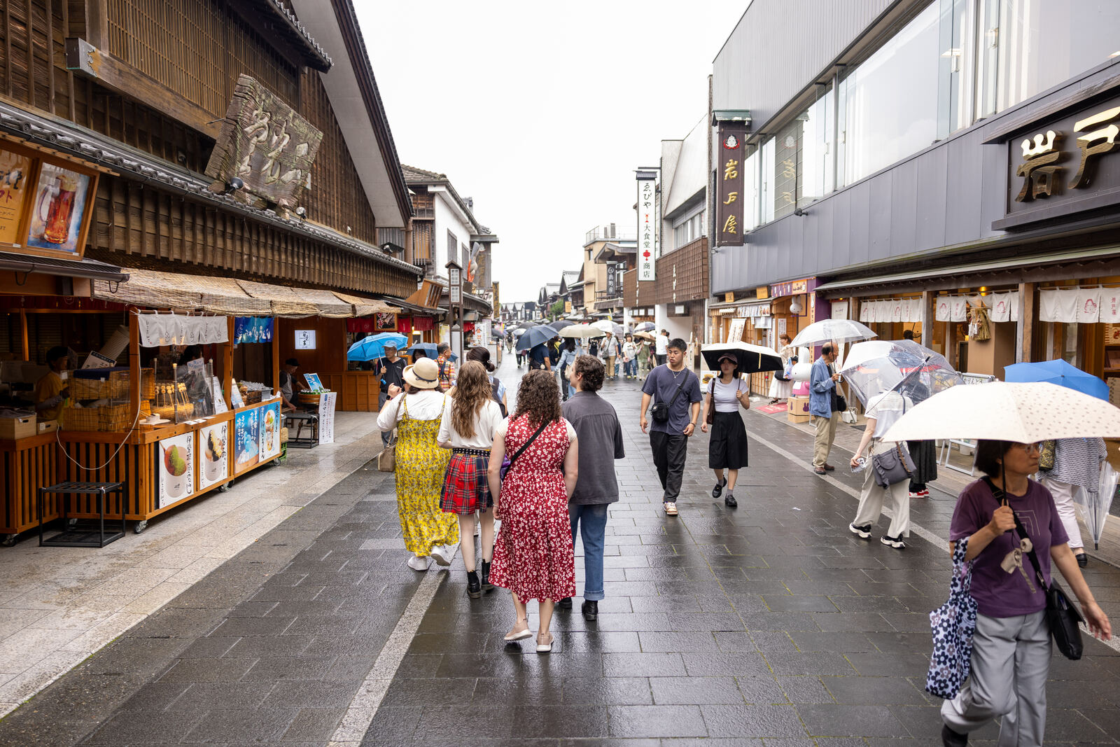 Guests walking down Okage Yokocho under umbrellas