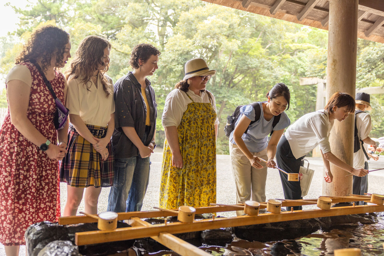 Guests using wooden ladles to purify their hands before entering the shrine