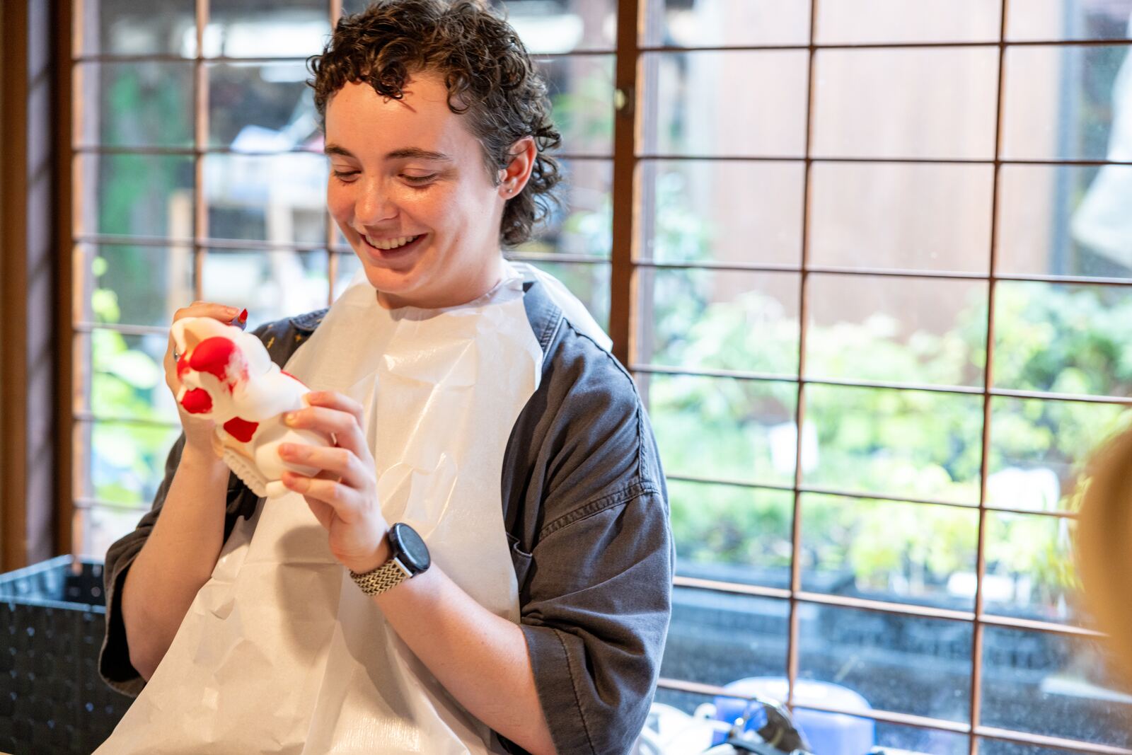 A guest carefully painting a maneki-neko lucky cat