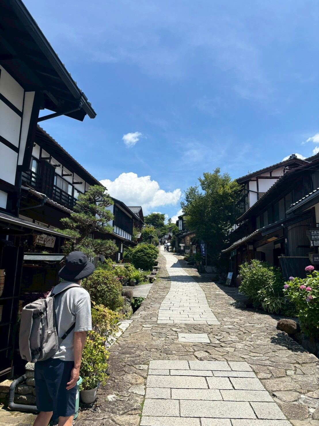 A guest walking down the sloped street of Magome